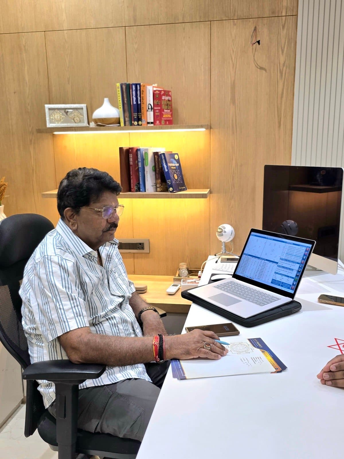 R P Pandey reading a KP chart during a consultation
